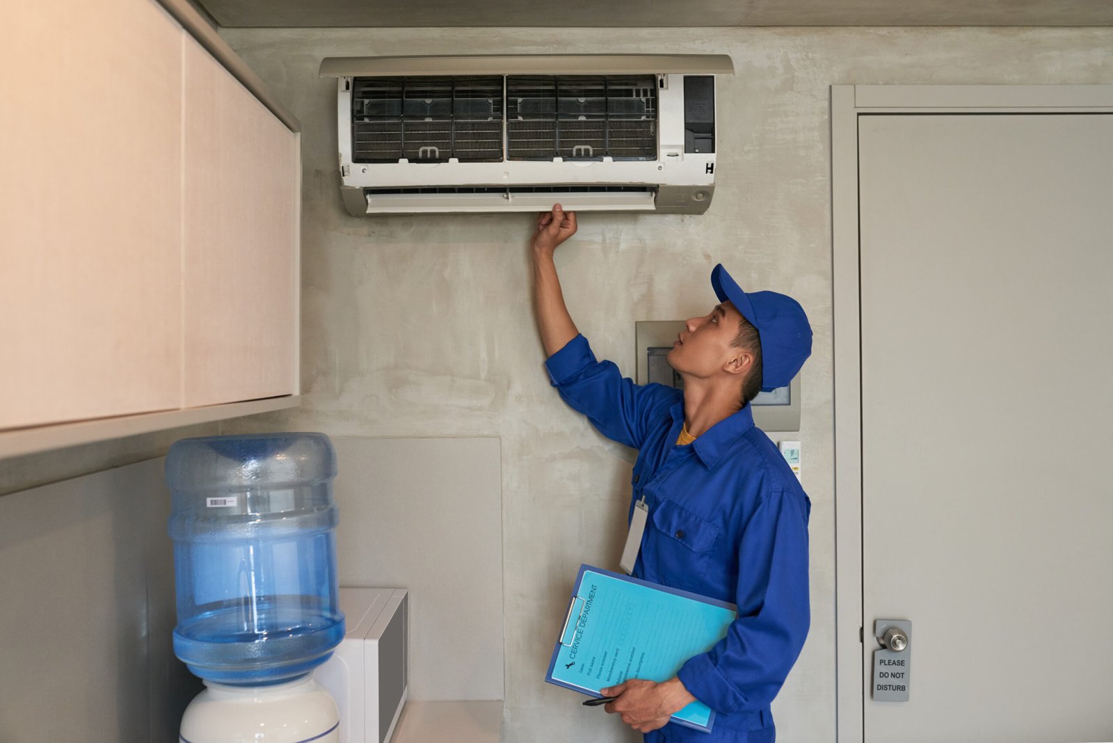 Checking conditioner Young Asian technician checking conditioner in kitchen